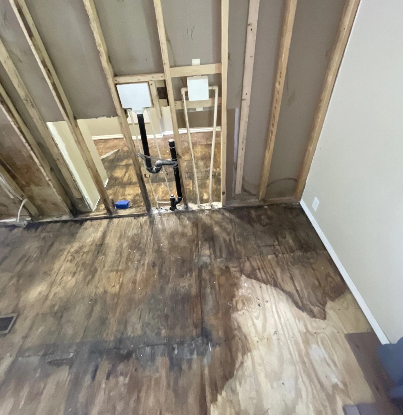 Exposed subfloor and wall studs after water damage extraction in Portland