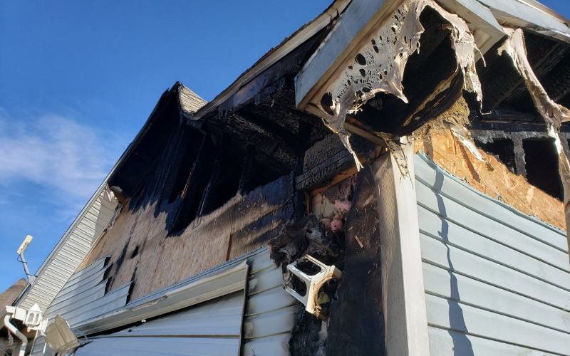 Exterior of a Portland house with fire damage to roof and siding